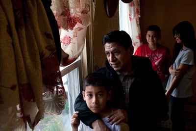 Vicente Ramos with his children in their home in New Brunswick, N.J., in March. Ramos recounted how he had to walk for three hours one night when the temp agency van didn't show. (Melanie Burford for ProPublica)