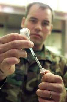 U.S. Navy Corpsman Thomas Williams fills a syringe with the anthrax vaccine before dispensing it (2003 Reuters file photo/Randy Davey)