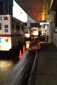 Water gushes out of a pump at Bellevue Hospital in New York as ambulances idle and wait for patients during the evacuation on Nov. 1. (Sheri Fink)
