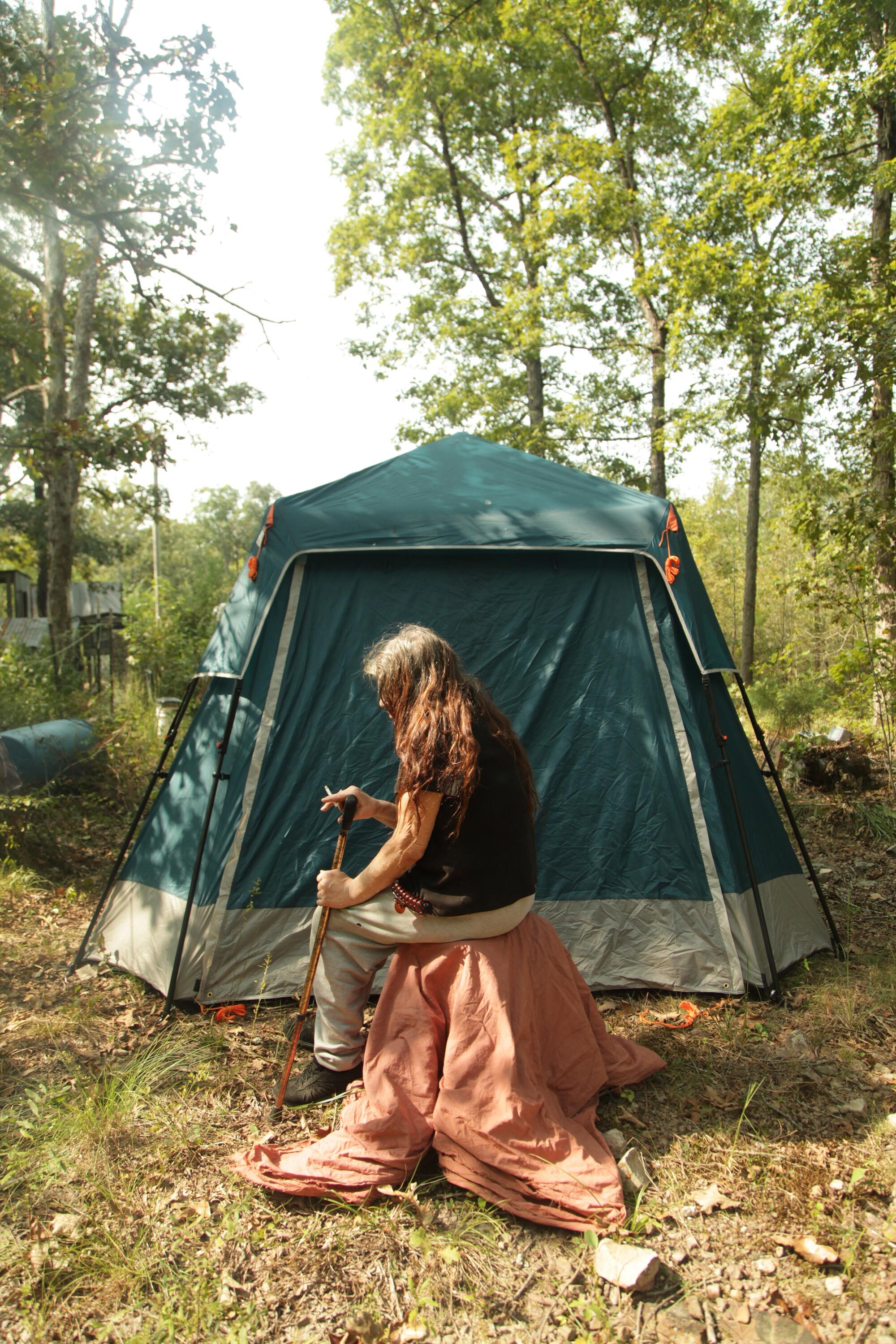 Jocelyn Mailly (woman with brown hair sitting in front of a green tent)