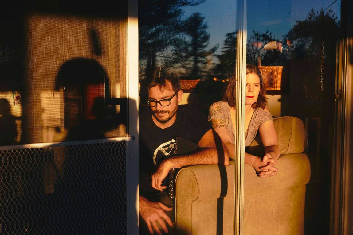 Peter Kalmus and Sharon Kunde sitting in magic hour light in their home.