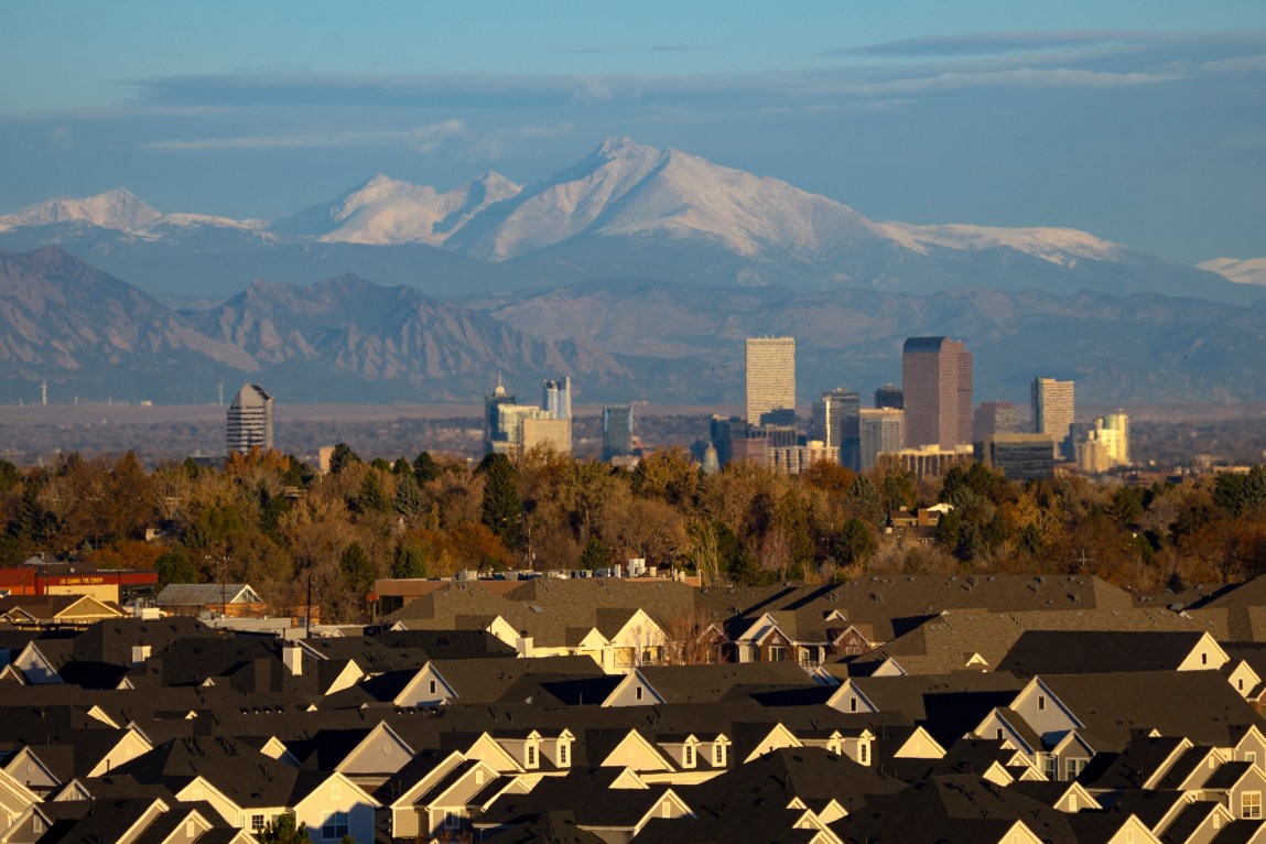 Roofs of houses in the foreground, Rocky Mountains in the background