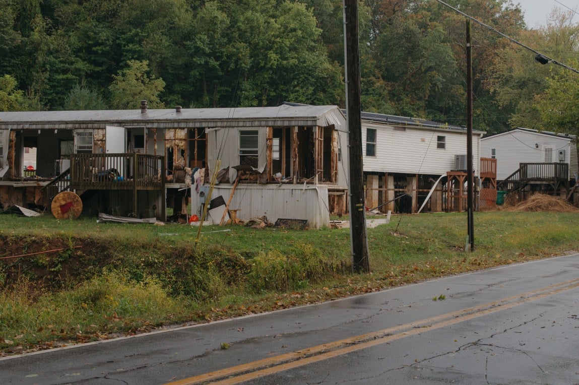 Several trailer homes that are missing walls and surrounded by debris.