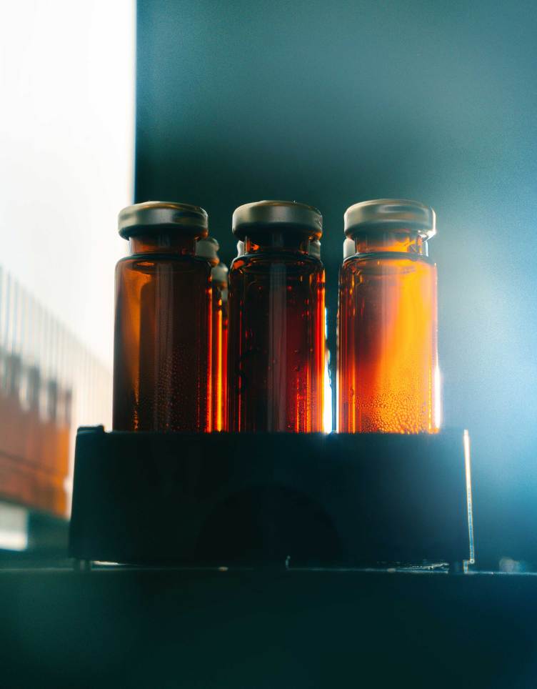 Three amber colored vials, with dramatic lighting.